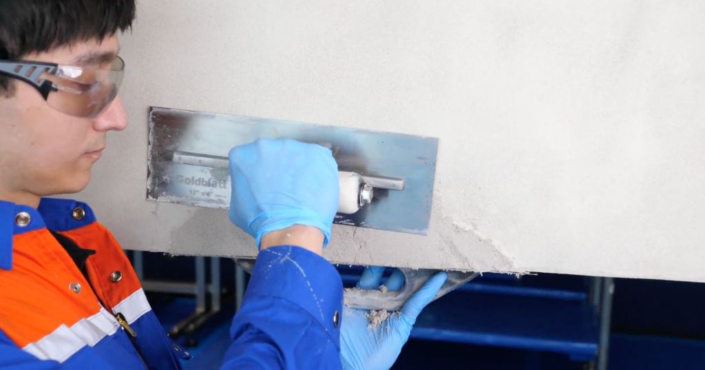 Acabado con llana de una reparación de concreto sobre cabeza