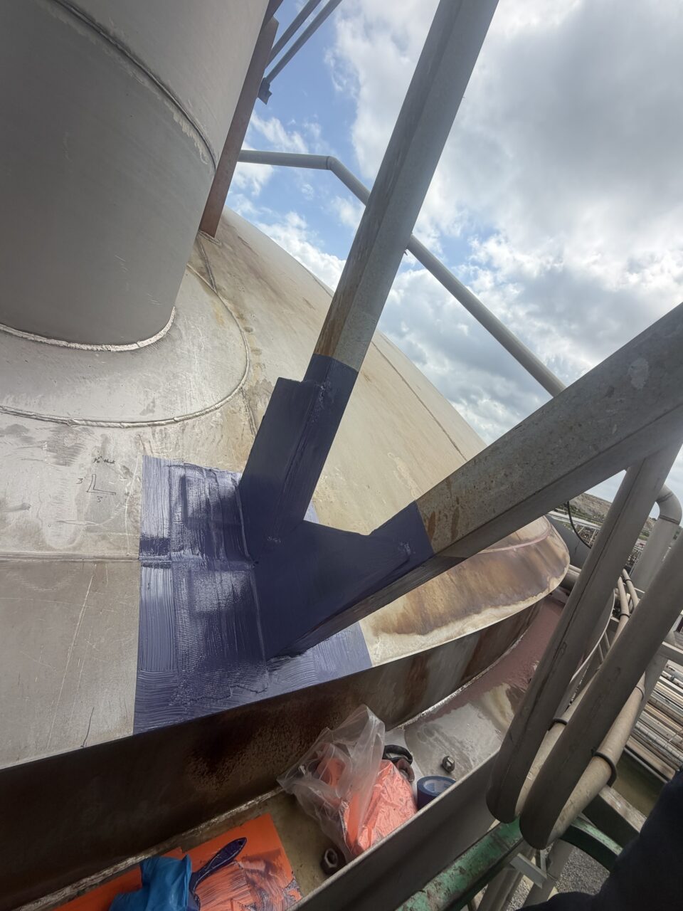 Completed metal bonding epoxy repair of corroded stair support brackets on a nitric acid storage tank. The cold-applied structural adhesive provided a durable alternative to welding in an operational chemical processing environment.