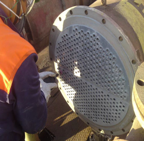 Removing the corks from the heat exchanger tube sheet.