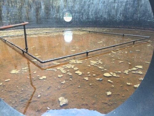 Water and hydrocarbons corroded the steel floor of a tank