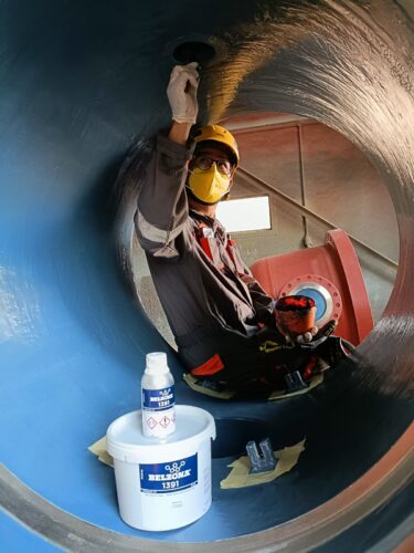 An applicator applies Belzona to the interior of a tank