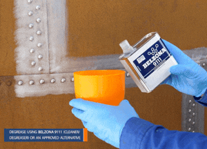 Brush away loose contaminants on the riveted tank and clean the surface with a suitable cleaner or degreaser