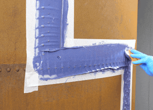 Use a stiff bristle brush to spread material evenly on the tank